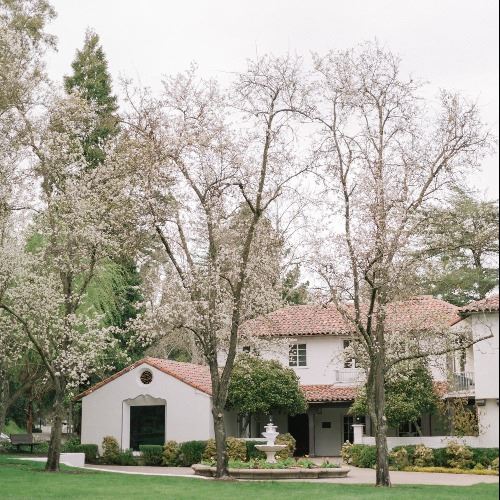 Photo of Hacienda de las Flores from the lawn looking at the fountain area on a grey day in early sp